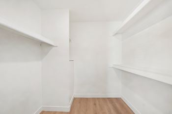 A white room with wooden floors and shelves.
